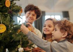 Niños participando en la decoración del árbol de Navidad familiar.