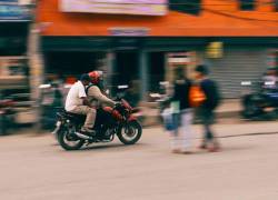 Fotografía referencial de dos hombres circulando en una motocicleta.