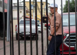 Fotografía de un residente de Guayaquil detrás de un portón metálico instalado en la calle donde vive.