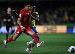 El defensor ecuatoriano Piero Hincapie (i) y el delantero brasileño Luiz Henrique luchan por el balón.