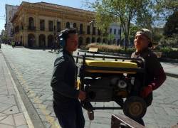 Empleados cargando un generador eléctrico.