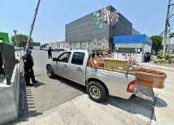 Se observa un vehículo de una funeraria cargando un ataúd afuera de la morgue de medicina forense en Guayaquil.