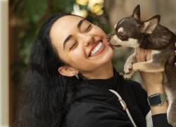 Una chica junto a su perrito recibiendo una dosis de amor.