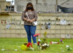 Fotografía fechada el 15 de febrero de 2022 muestra a Blanca Reyes, hija de Julio Reyes, mientras visita la tumba de su padre, fallecido en un hospital el 28 de marzo de 2020, tan solo un mes después de que se confirmase el primer caso de coronavirus en Ecuador, en Guayaquil (Ecuador).