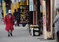 Quito, Ecuador (Viernes 4 de octubre del 2024).- Transeúntes caminan delante de un local con generador de energía, por la avenida 19 de Agosto y Patria.