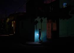 Fotografía referencial de un niño caminando en una calle a oscuras.