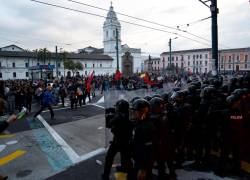 Manifestantes se enfrentan a la policía durante una protesta, este viernes, en Quito.