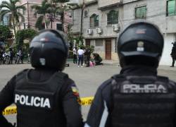 Fotografía de policías observando el cadáver de una víctima de asesinato, el 18 de julio de este año, en un parqueadero de la 4 etapa del El Recreo, en Durán.