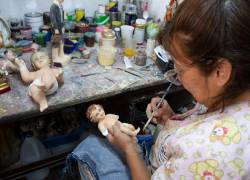 Una mujer trabajando en una escultura religiosa.