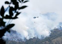 Fotografía sin fecha cedida por el Cuerpo de Bomberos de Cuenca de un helicóptero combatiendo un incendio forestal en el Parque Nacional Cajas, en Cuenca.