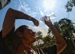 Mujer se hidrata por el calor que azota a la ciudad.