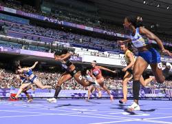 La liberiana Ebony Morrison (C) cruza la línea de meta por delante de la ecuatoriana Maribel Vanessa Caicedo Vernaza (R) en la ronda de repechaje de 100 metros con vallas femenina de la prueba de atletismo de los Juegos Olímpicos París 2024 (Foto: AFP)