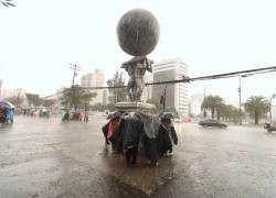 Personas se protegen de la lluvia en una zona del norte de Quito.