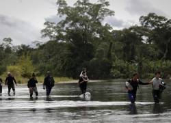 Migrantes cruzan el río Tuquesa luego de atravesar la selva del Darién, este jueves en el Darien (Panamá).