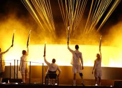 Los portadores de la antorcha paralímpica de Francia, Charles-Antoine Kaoukou, Nantenin Keita, Fabien Lamirault, Alexis Hanquinquant y Elodie Lorandi sostienen la llama Paralímpica frente al pebetero Paralímpico