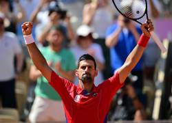 El Novak Djokovic levanta sus brazos para celebrar su triunfo ante Rafael Nadal en tenis de París 2024.