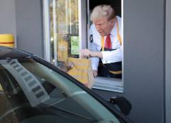 El candidato presidencial republicano y ex presidente de EE. UU., Donald Trump, atendiendo la fila del servicio de autos.