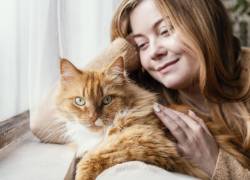 Una joven junto a su gatito.