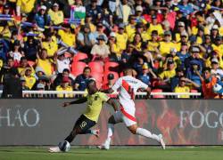 Enner Valencia (i) disputa un balón con Marcos López de Perú.