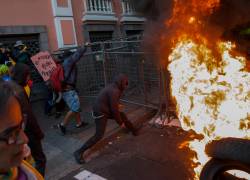 Manifestantes empujan una reja junto a una barricada durante una protesta contra el Gobierno del presidente, Daniel Noboa.