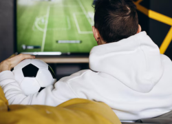 Fotografía referencial de un hombre viendo un partido de fútbol.