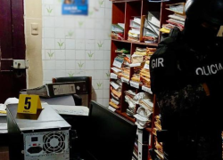 Fotografía de elementos policiales levantando indicios en una oficina.