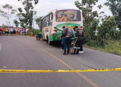 Fotografía de la escena del siniestro, en la que se observa el bus involucrado y la motocicleta delante.