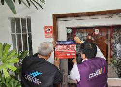 Fotografía de agentes colocando el sello de clausura a la entrada del restaurante.