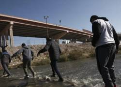 Migrantes cruzando un río en el trayecto de México hacia el norte.