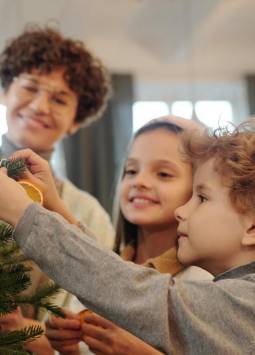 Niños participando en la decoración del árbol de Navidad familiar.