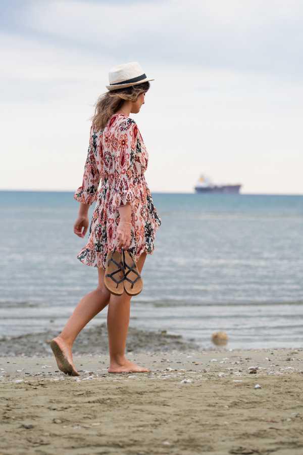 $!Mujer dando una caminata sin zapatos por la playa.