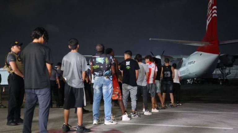 $!Una fila de migrantes ecuatorianos esperando a ser deportados desde Panamá en un avión.