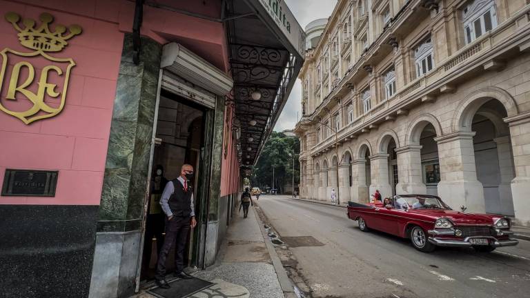 $!Un hombre parado en el frente El Floridita el bar de La Habana donde se puede encontrar una estatua de bronce del novelista Ernest Hemingway.