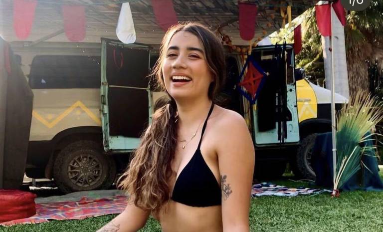 $!Fotografía de María Fernanda frente a una van. Su apariencia es de entre 23 y 25 años, de entre 1,50 y 1,55 de estatura, de complexión delgada, pelo largo y oscuro, y tatuajes florales en ambos brazos.