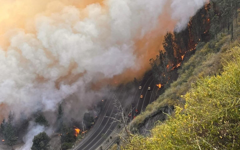 $!Vista aérea de un tramo de la avenida Simón Bolívar invadido por el humo de llamas próximas.