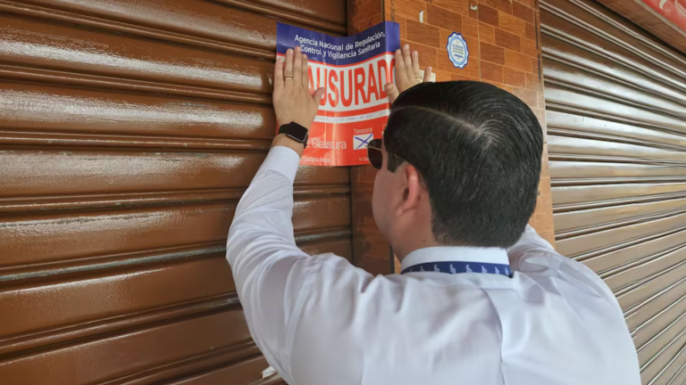 Fotografía de un técnico poniendo el sello de clausura del lugar.