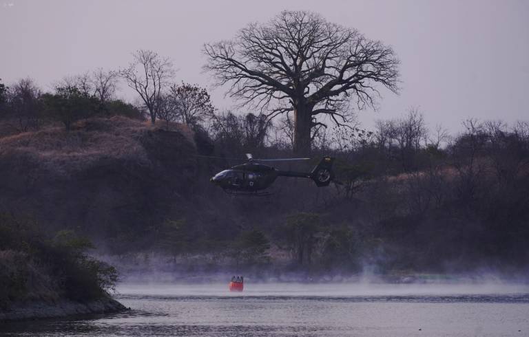 $!Un helicóptero recoge agua de una pequeña laguna cerca de la zona del flagelo.