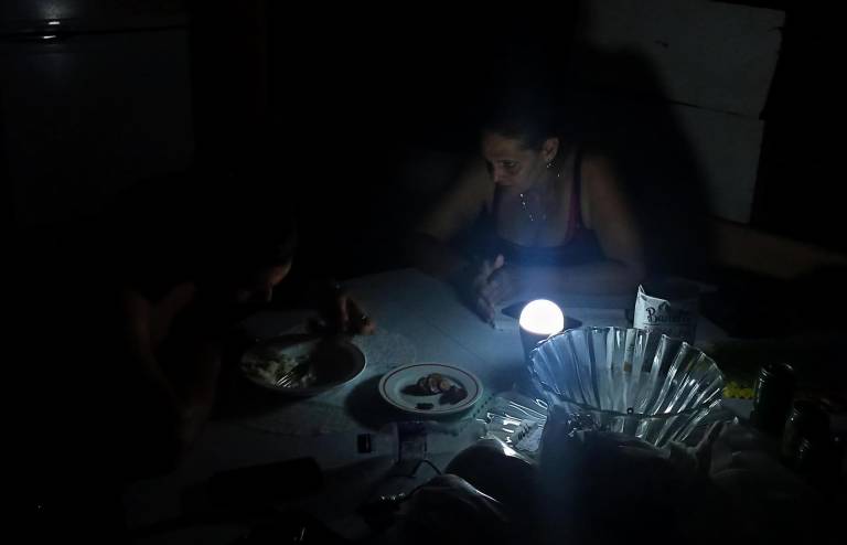 $!Fotografía de archivo de una mujer conversando con su hijo durante un apagón.