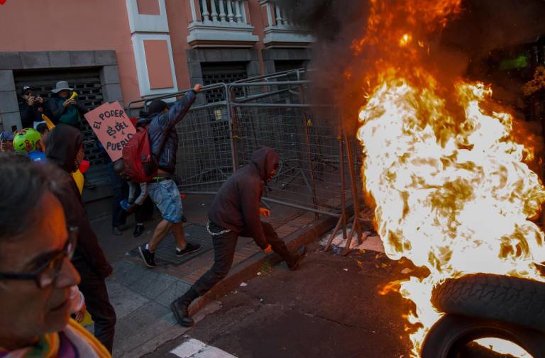 $!Manifestantes empujan una reja junto a una barricada durante una protesta contra el Gobierno del presidente, Daniel Noboa.