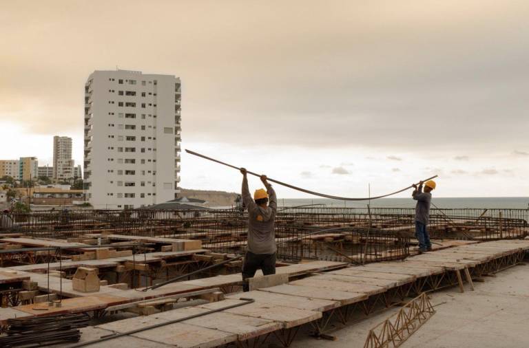 $!Dos colaboradores de Etinar sostienen unas varillas en un proyecto inmobiliario.