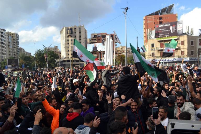 $!La gente porta banderas sirias de la oposición mientras celebran la toma rebelde de Damasco, en Trípoli, norte del Líbano, el 8 de diciembre de 2024.