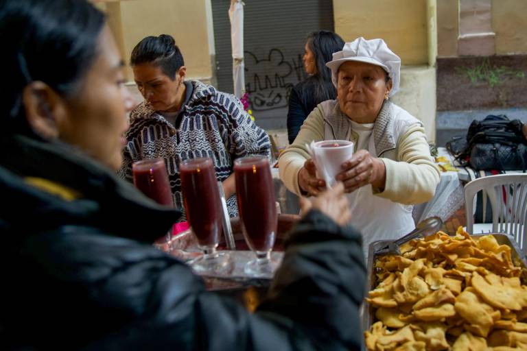 $!Una mujer ofrece colada morada el pasado jueves en una calle de Quito.