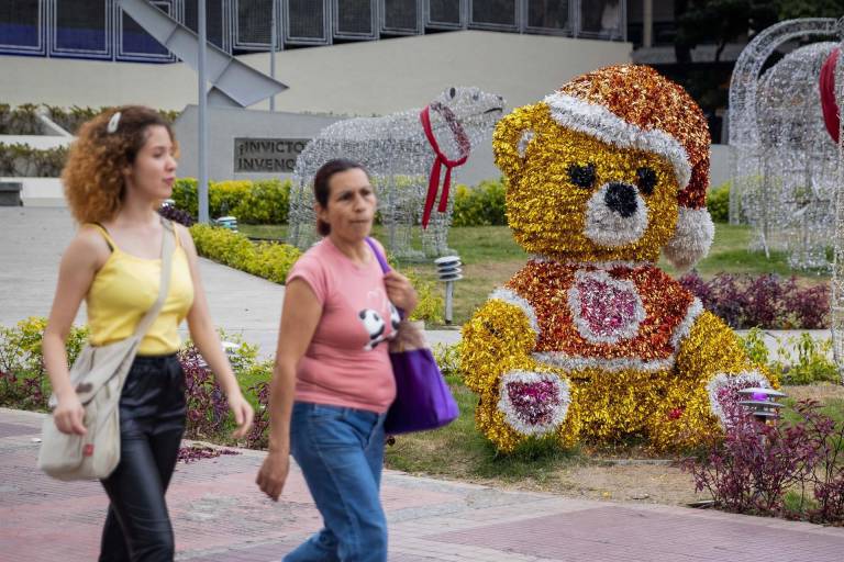 $!Dos mujeres caminan en una plaza con decoración navideña hoy, en Caracas.