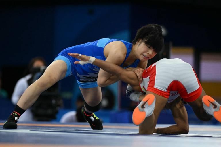 $!La ecuatoriana Lucía Yamileth Yepez Guzmán (roja) lucha contra la japonesa Akari Fujinami (azul) en su partido final de lucha libre femenina de 53 kg durante los Juegos Olímpicos París 2024. (Foto:AFP)