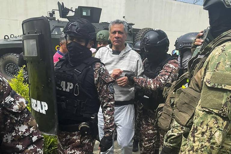 $!Esta fotografía difundida por la Policía ecuatoriana muestra al ex vicepresidente ecuatoriano Jorge Glas escoltado por miembros del Grupo de Acción Penitenciaria Especial.