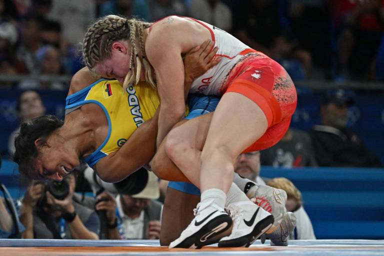 $!La canadiense Hannah Fay Taylor (roja) lucha contra la ecuatoriana Luisa Elizabeth Valverde Melendres (azul) en su partido de repechaje de lucha libre femenina de 57 kg durante los Juegos Olímpicos de París 2024. (Foto: AFP)