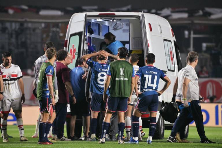 $!El defensa de Nacional Juan Manuel Izquierdo (cubierto) es trasladado en una ambulancia tras desplomarse en el suelo durante la Copa Libertadores.