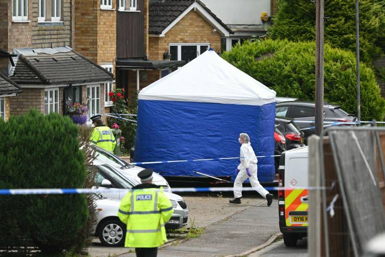 $!Un miembro del equipo forense pasa junto a una tienda de campaña instalada detrás de un cordón en Ashley Close en Bushey, en el distrito de Hertfordshire, al norte de Londres.