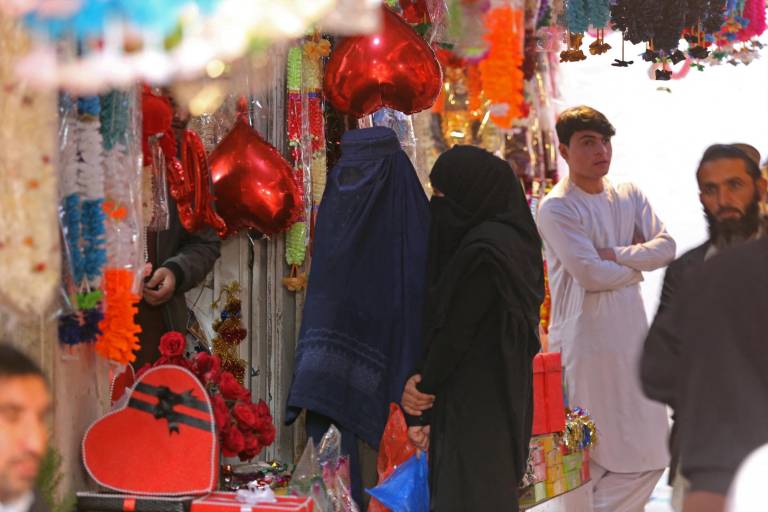 $!Mujeres afganas vestidas con burka compran regalos en una tienda con motivo del Día de San Valentín en Jalalabad el 14 de febrero de 2023.