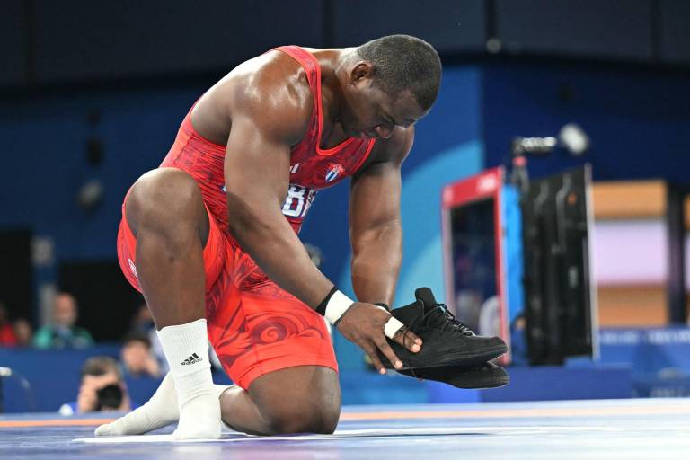 $!El cubano Mijaín López Núñez se quita los zapatos como señal de que se retira después de vencer al chileno Yasmani Acosta Fernández en la final de lucha grecorromana masculina de 130 kg. (Foto: AFP)